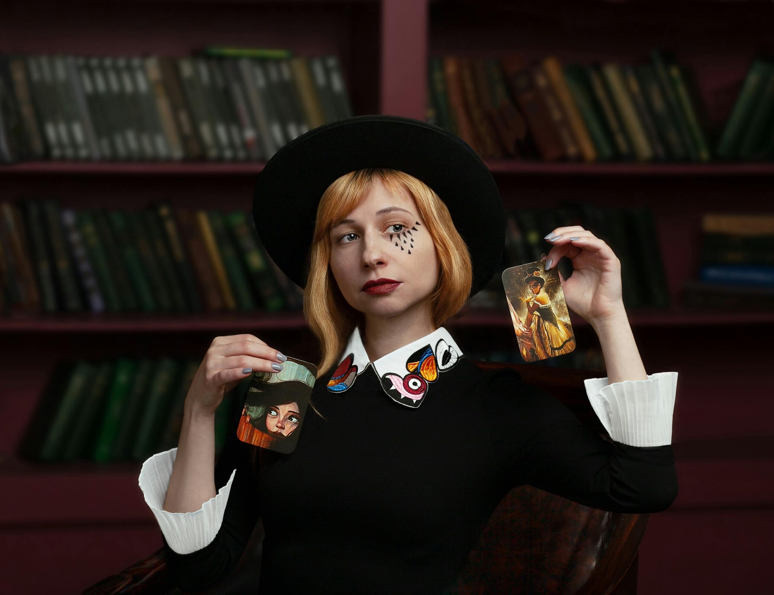 A stylish female magician performing with tarot cards in a library setting, showcasing creativity and elegance.